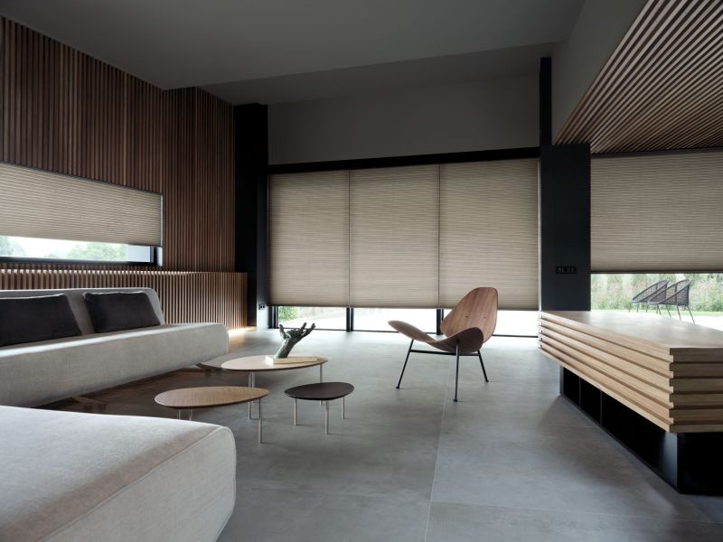 Persiana celular com estrutura em colmeia, instalada na janela, oferecendo isolamento térmico e acústico, com design clean e controle suave de luz em ambiente moderno.