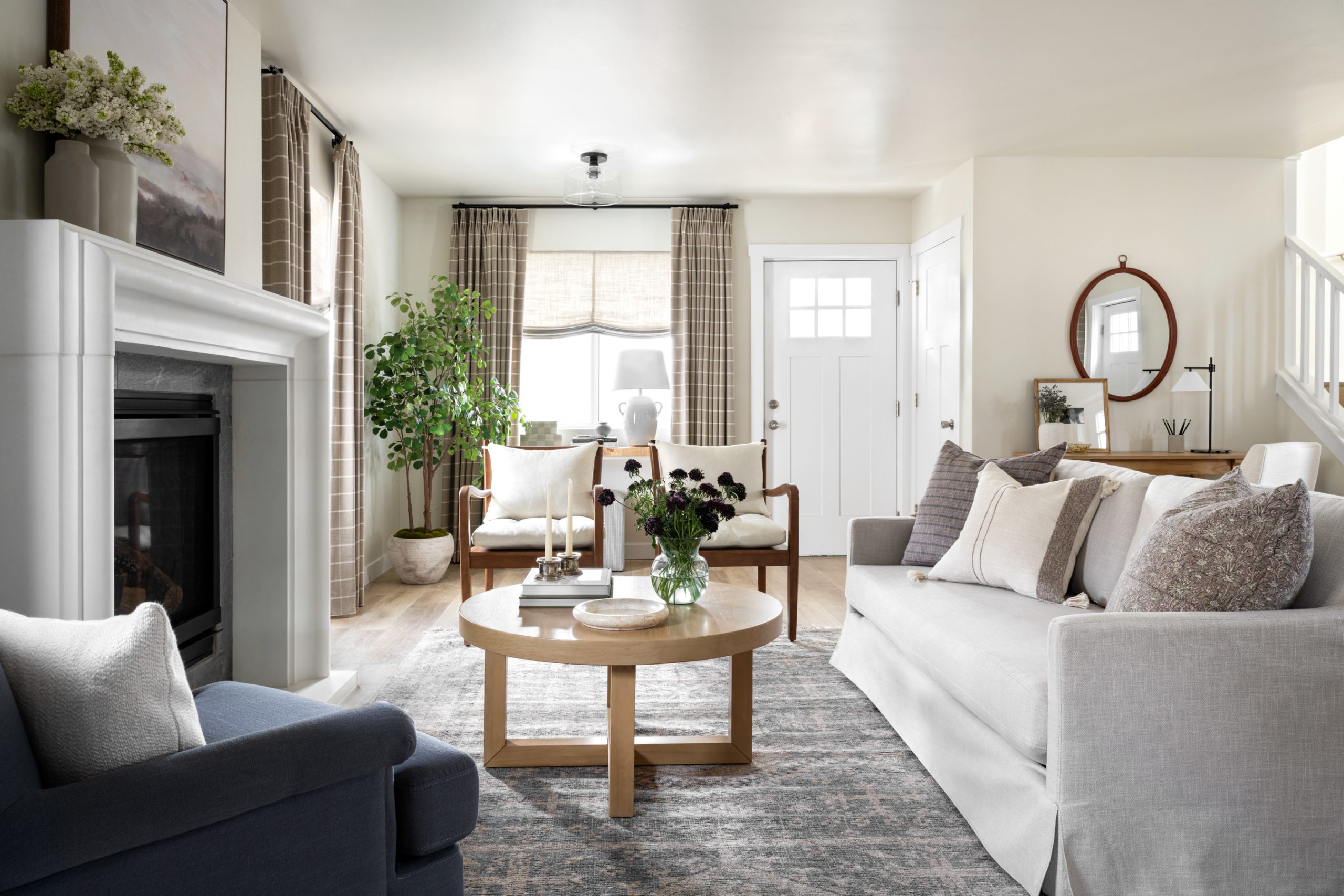 Sala de estar aconchegante com cortinas de tecido em tons neutros, sofá claro com almofadas decorativas e mesa de centro em madeira