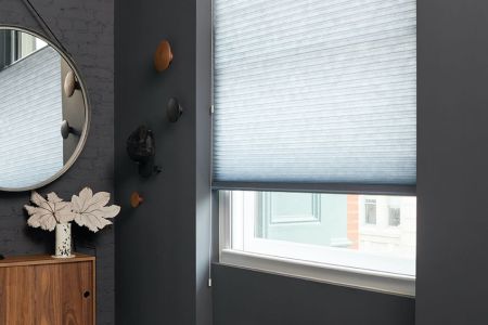 Ambiente elegante com persianas Duo Vision em tons neutros, combinando paredes de pedra e móveis modernos para criar sofisticação e conforto.